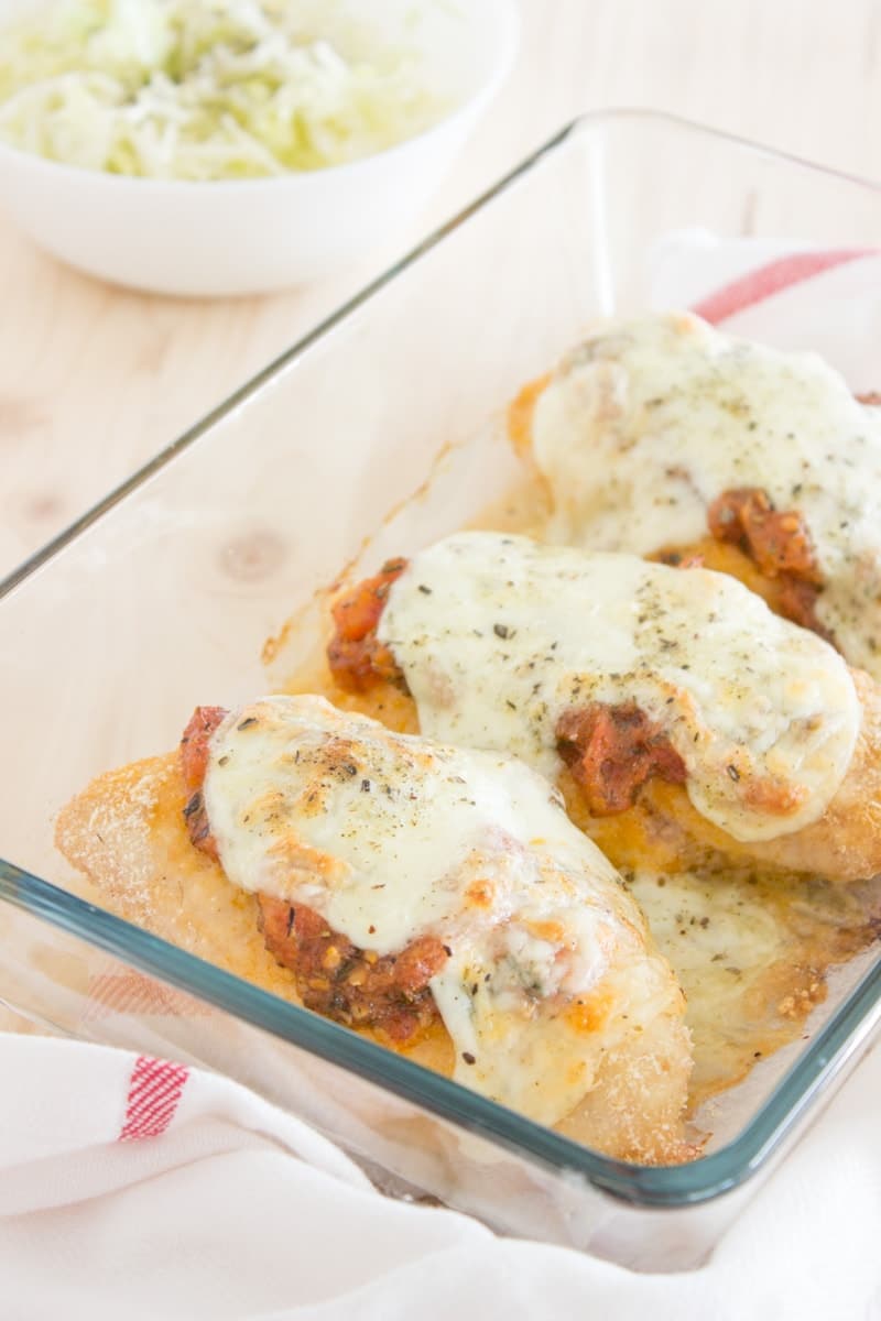 Easy Chicken Parmesan baked in the oven with mozzarella cheese and homemade tomato sauce, seasoned with fragrant spices. This dish is made without added fat, which makes this meal super healthy and low-fat. Perfect weekday dinner your family will love. CLICK to read more or PIN for LATER!