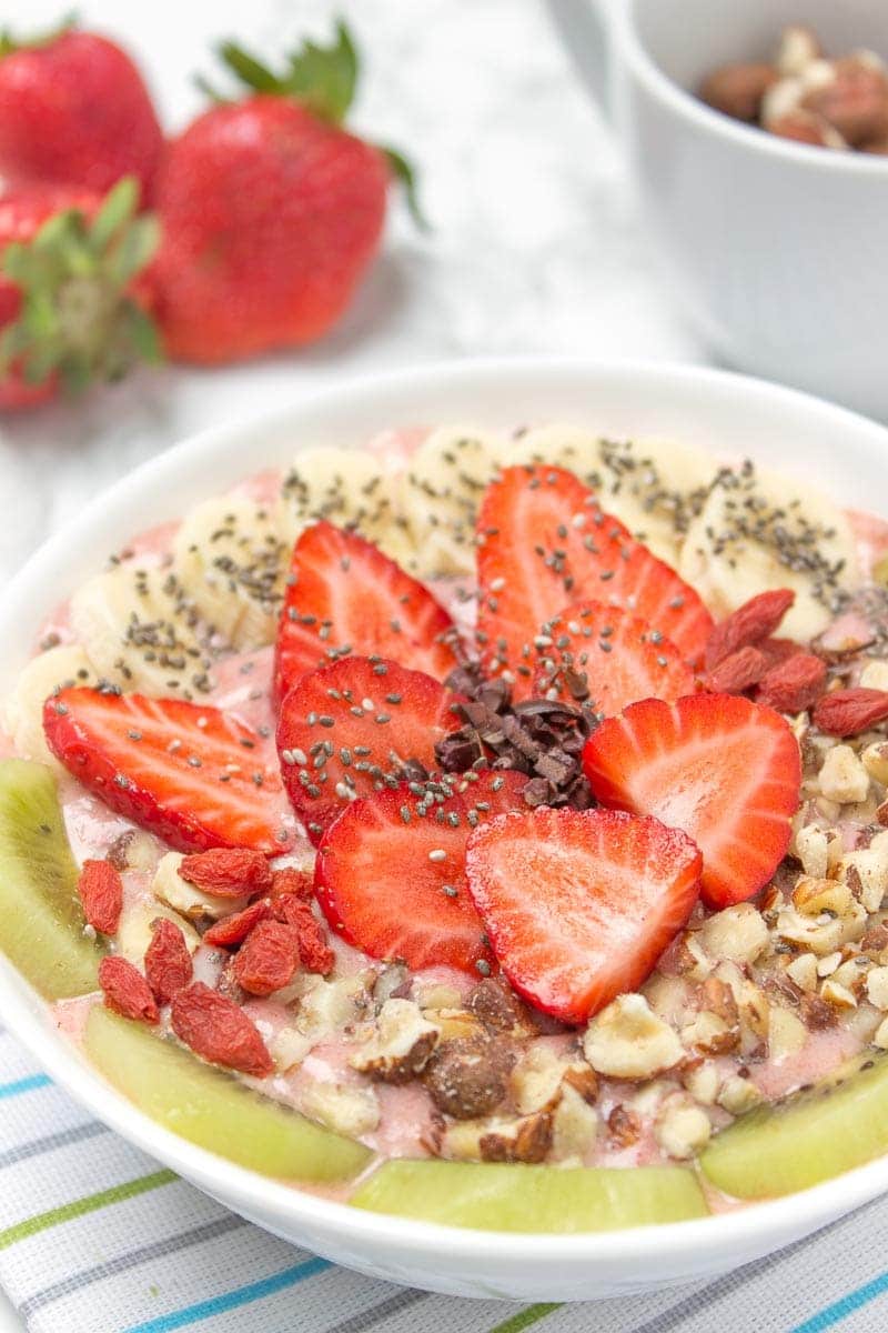 Creamy and sweet with a kick of spicy ginger, this immune boosting Strawberry Ginger Smoothie Bowl is a fresh and HEALTHY breakfast done in just minutes! Packed with nutrients, low calorie and WITHOUT added sugars. Vegan, gluten free and dairy free. DELICIOUS! #vegan #glutenfree #dairyfree #sugarfree #healthy #smoothie #recipe #breakfast #kids