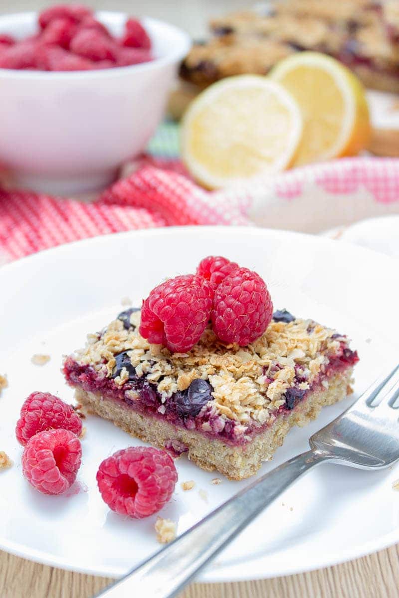 Wholesome Berry Banana Breakfast Oat Bars filled with fresh raspberries and blueberries, made with all HEALTHY ingredients. These bars are vegan, dairy-free, refined sugar-free and gluten-free. Perfect low-calorie summer breakfast that the whole family will devour. #vegan #glutenfree #sugarfree #dairyfree #healthy #oatmeal #oats #family #kidsfriendly #whole30 #weightloss #skinny #lowcalorie #wholegrain | natalieshealth.com