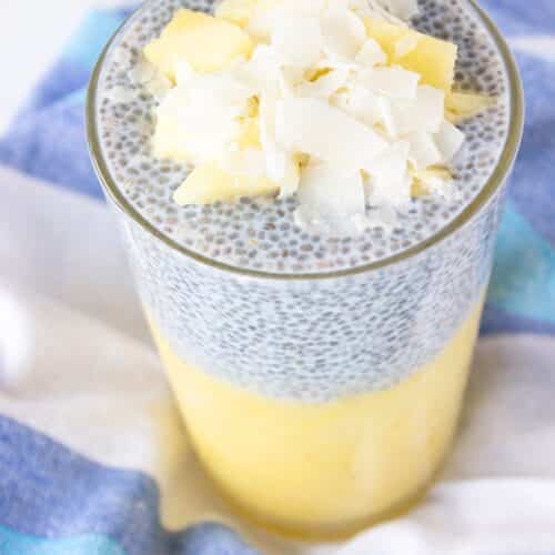 Pineapple coconut chia pudding layered with pineapple puree and topped with fresh pineapple and coconut flakes