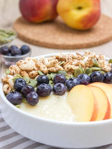 Pineapple Peach Smoothie Bowl with fresh blueberries and pumpkin seeds