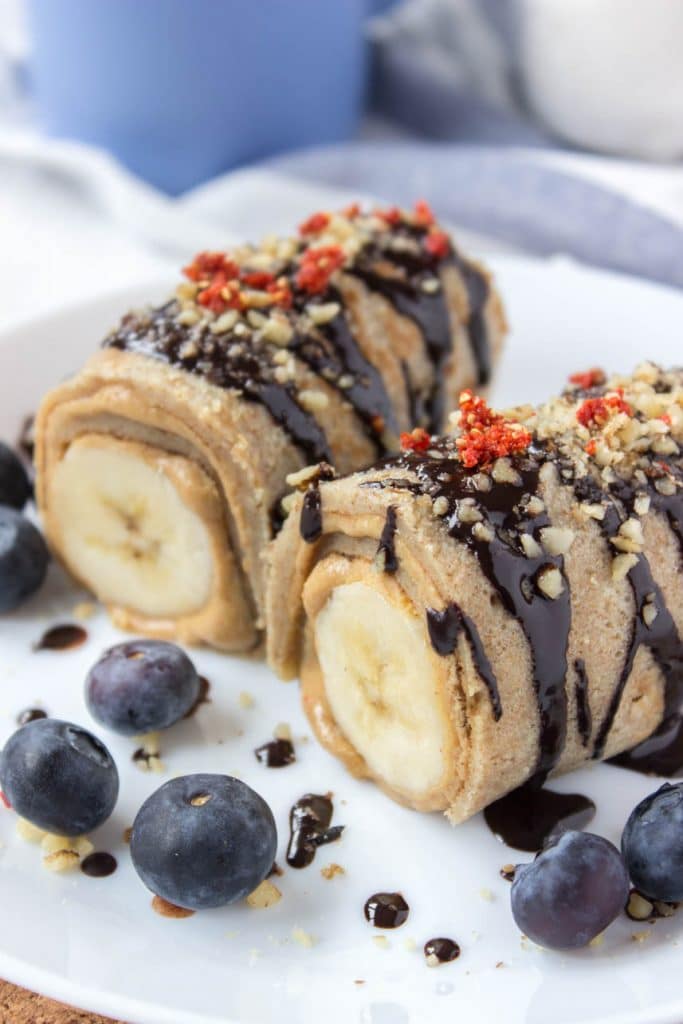 Chocolate Peanut Butter Banana Roll-Ups with crepes peanut butter and bananas drizzled with raw chocolate.