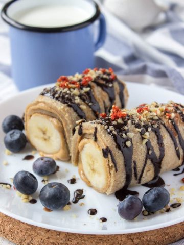 Chocolate Peanut Butter Banana Roll-Ups with crepes peanut butter and bananas drizzled with raw chocolate.