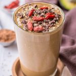 Chocolate Avocado Smoothie served in a smoothie glass topped with goji berries and chocolate