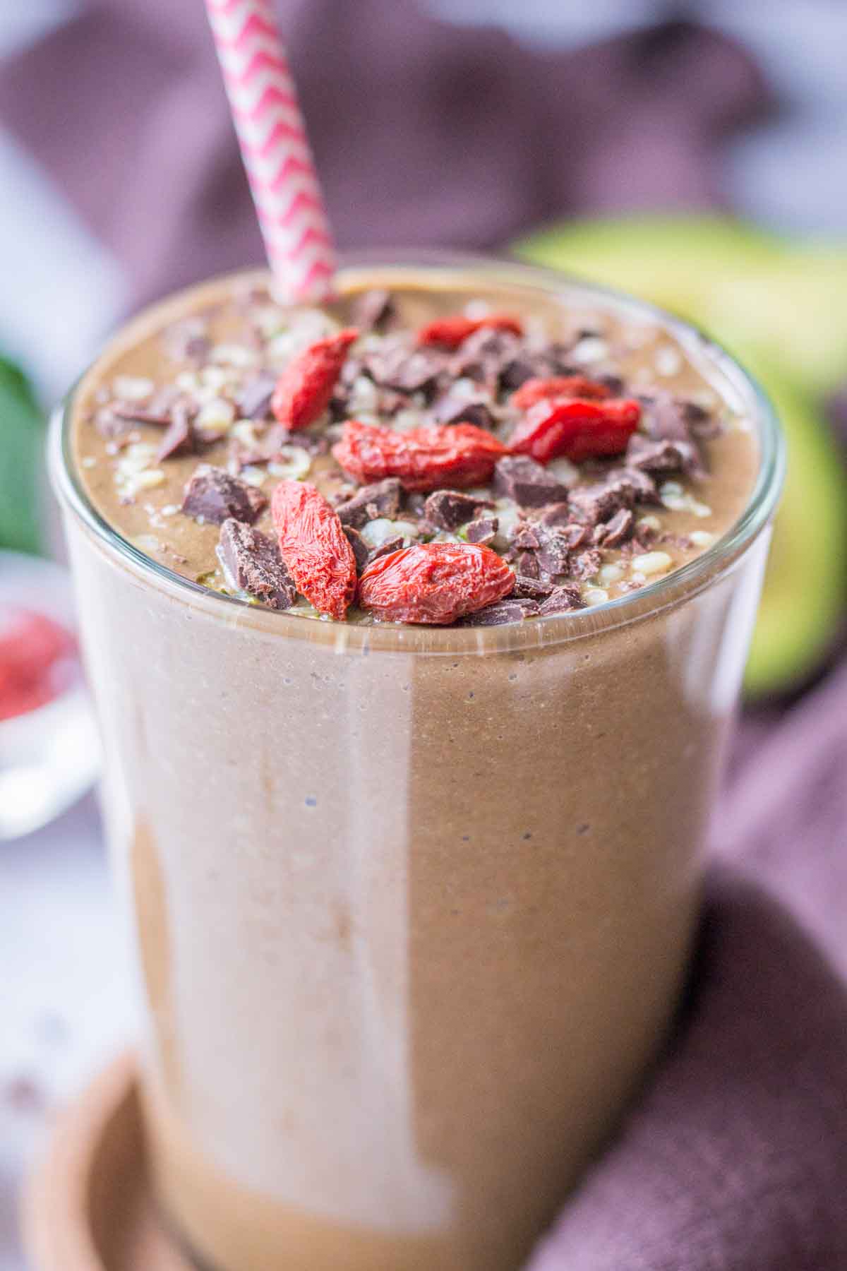 Chocolate Avocado Smoothie served in a smoothie glass topped with goji berries and chocolate