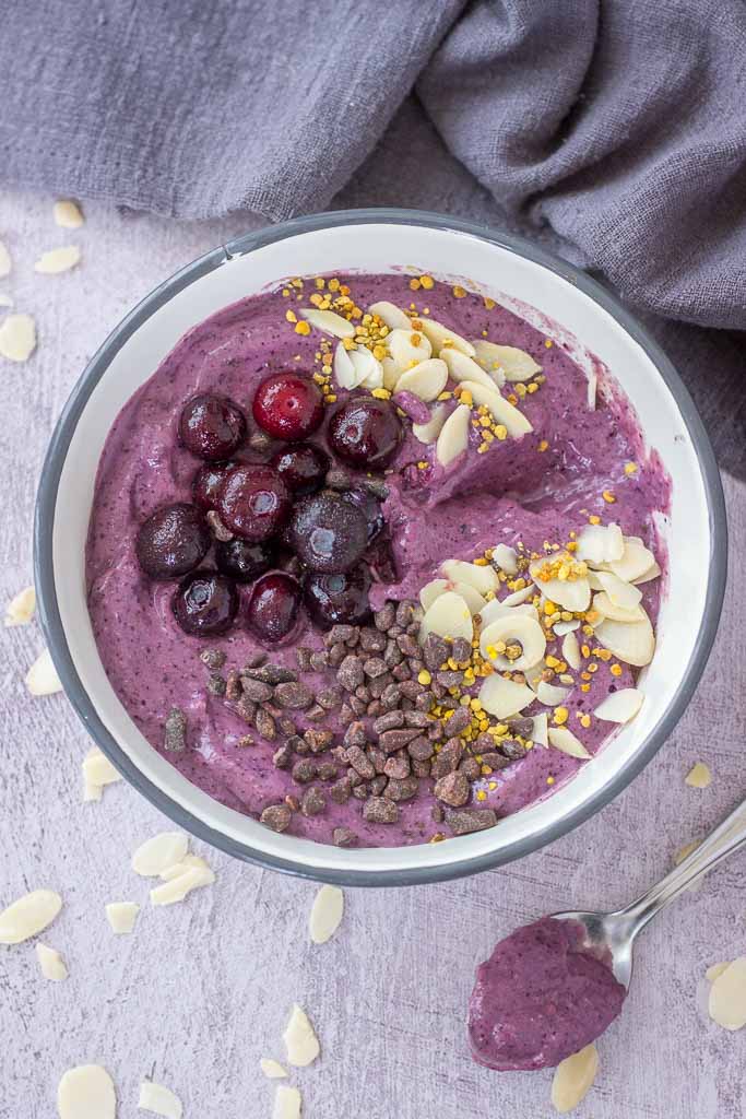 Blueberry Avocado Smoothie served in a bowl topped with blueberries almonds and chocolate