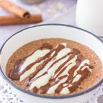 Cinnamon Roll Oatmeal porridge served in a bowl with cinnamon glaze and vanilla yogurt