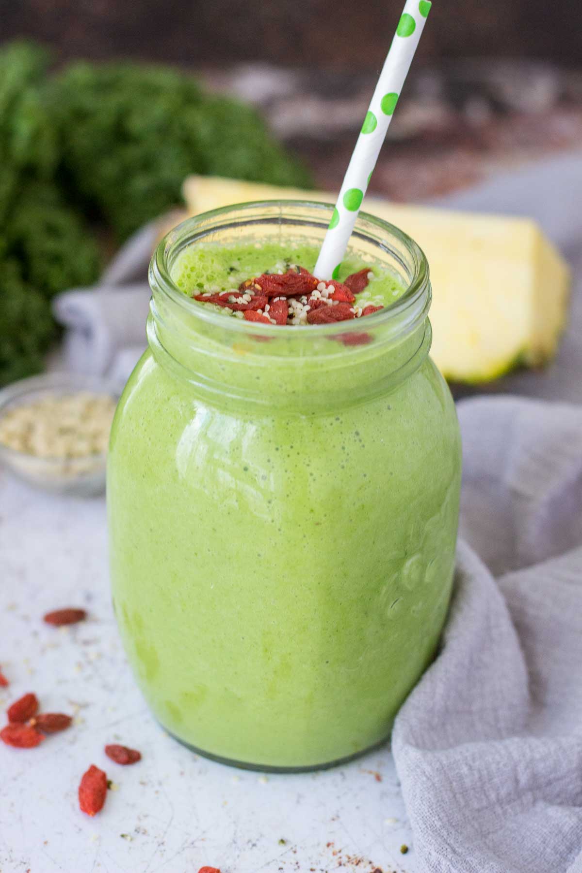 Kale Pineapple Smoothie served in a glass with the straw