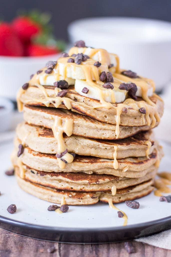 Peanut Butter Oatmeal Pancakes topped with banana, maple peanut butter syrup, and chocolate
