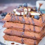 Chocolate Banana Waffles topped with chocolate syrup and fresh fruits