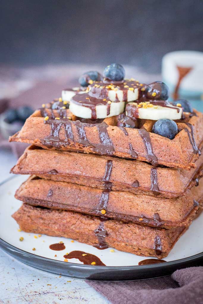 Chocolate Banana Waffles topped with chocolate syrup and fresh fruits