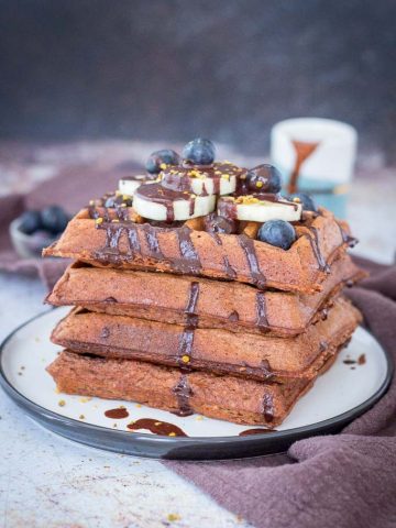 Chocolate Banana Waffles topped with chocolate syrup and fresh fruits