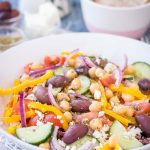 Greek Chickpea Salad with tomatoes, cucumber, olives, feta, and Greek Salad Dressing served in a bowl