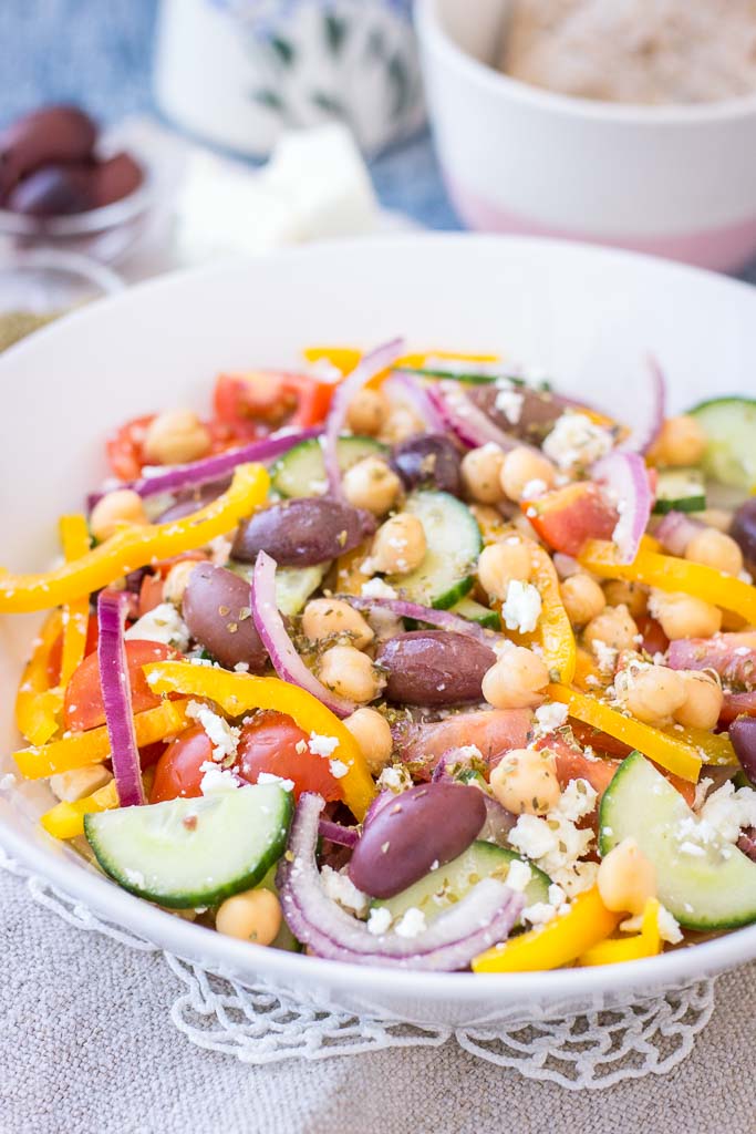 Greek Chickpea Salad with tomatoes, cucumber, olives, feta, and Greek Salad Dressing served in a bowl