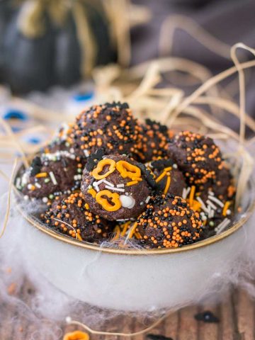 Halloween Brownie Bites made with dark chocolate rolled in Halloween sugar sprinkles served in a bowl