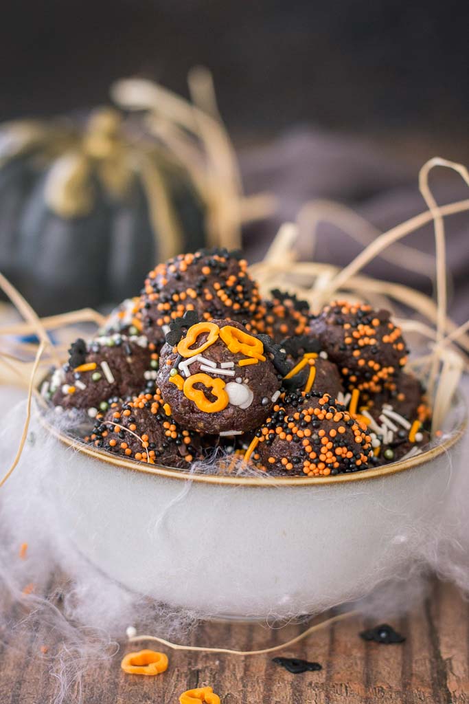 Halloween Brownie Bites made with dark chocolate rolled in Halloween sugar sprinkles served in a bowl