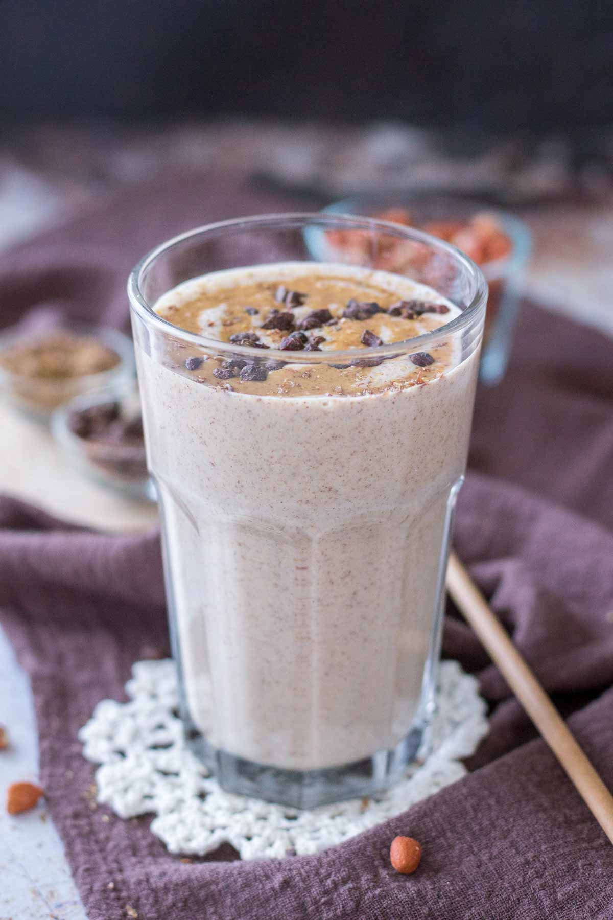 Peanut Butter Protein Shake in a glass topped with peanut butter and chocolate