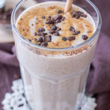 Close up of a Peanut Butter Protein Shake in a glass topped with peanut butter