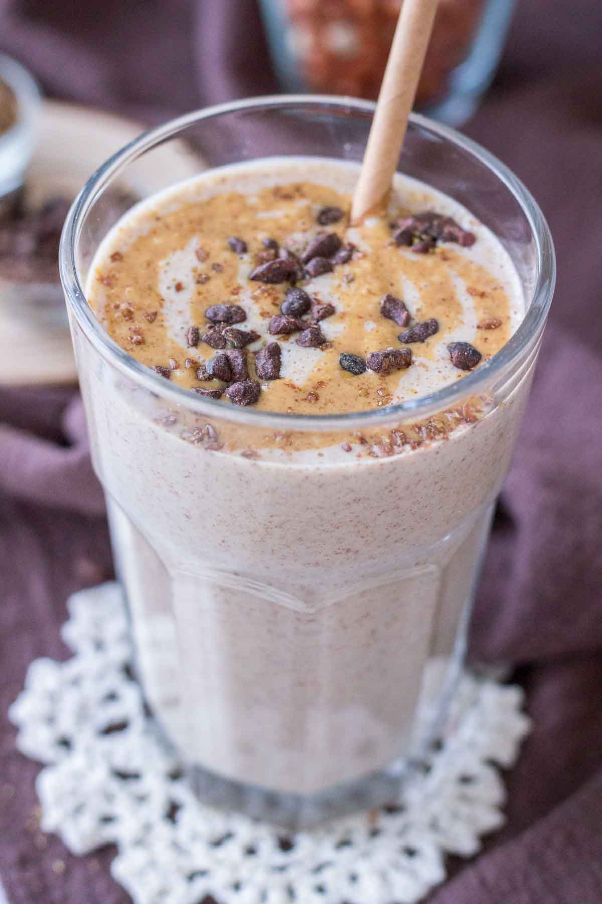 Close up of a Peanut Butter Protein Shake in a glass topped with peanut butter