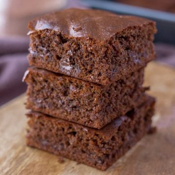 Almond butter brownies sliced and served on a wooden plate