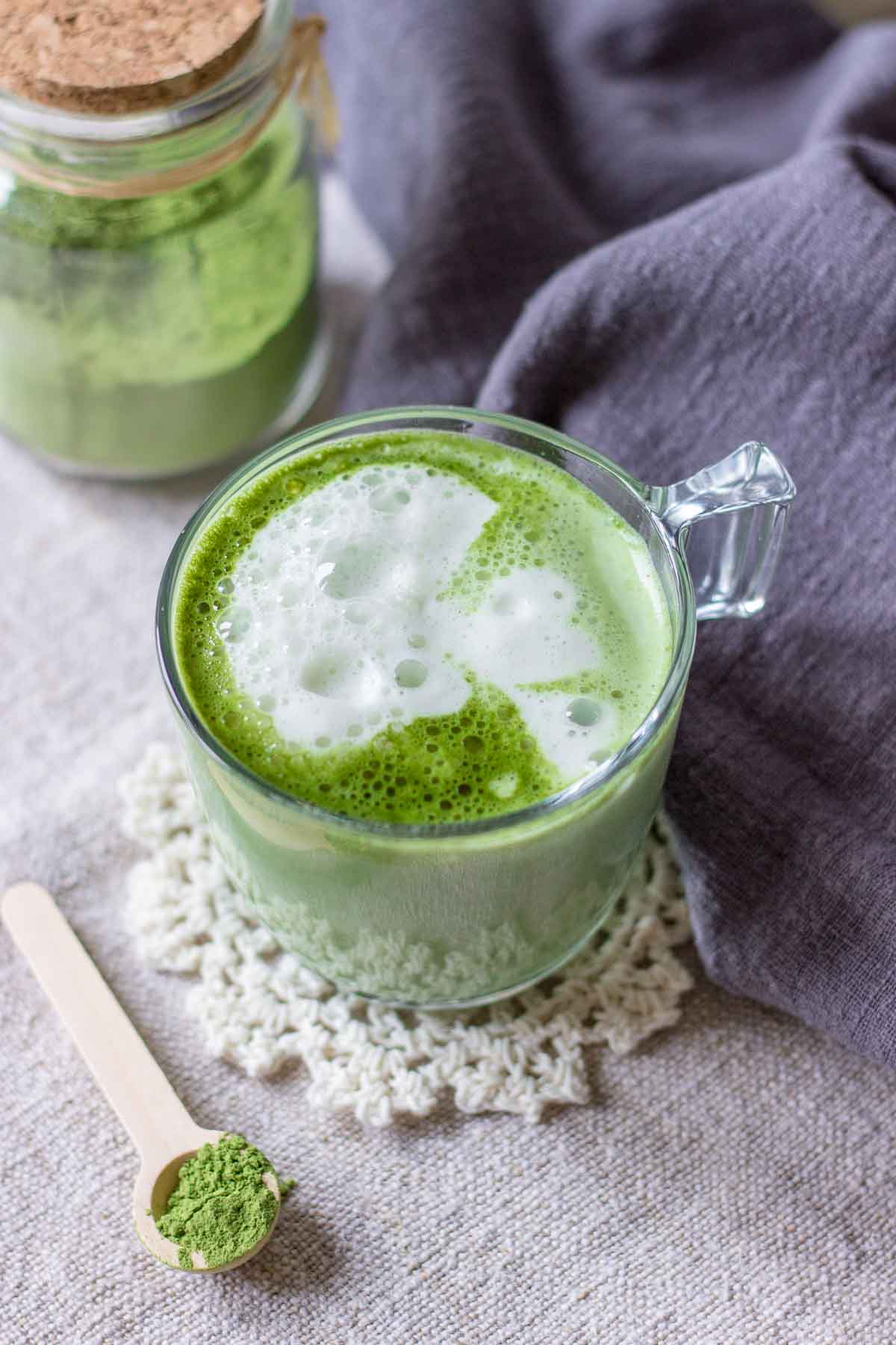 Upper view of a matcha green tea latte served in a mug with frothed milk