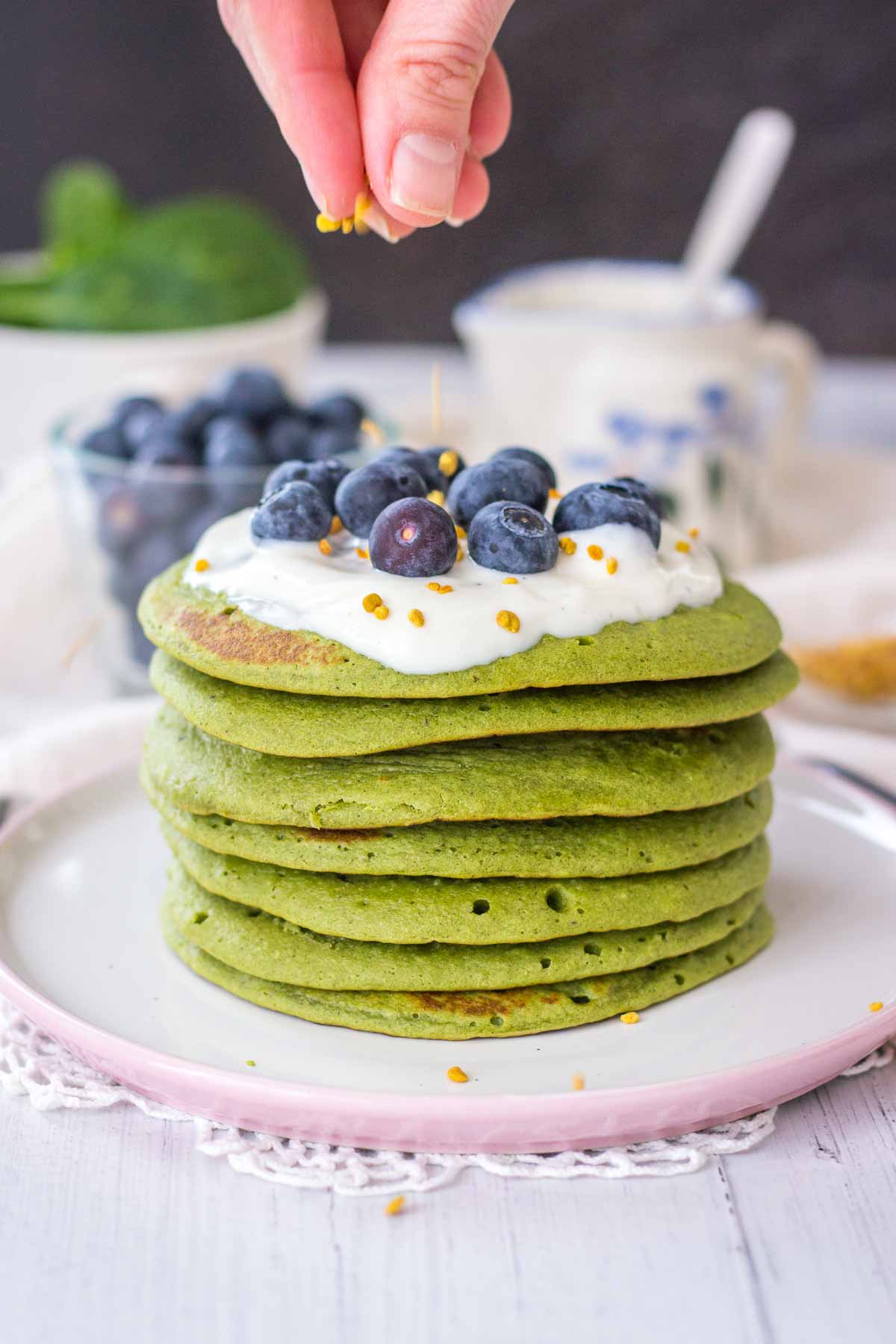 Matcha Pancakes topped with yogurt and blueberries served on a plate.