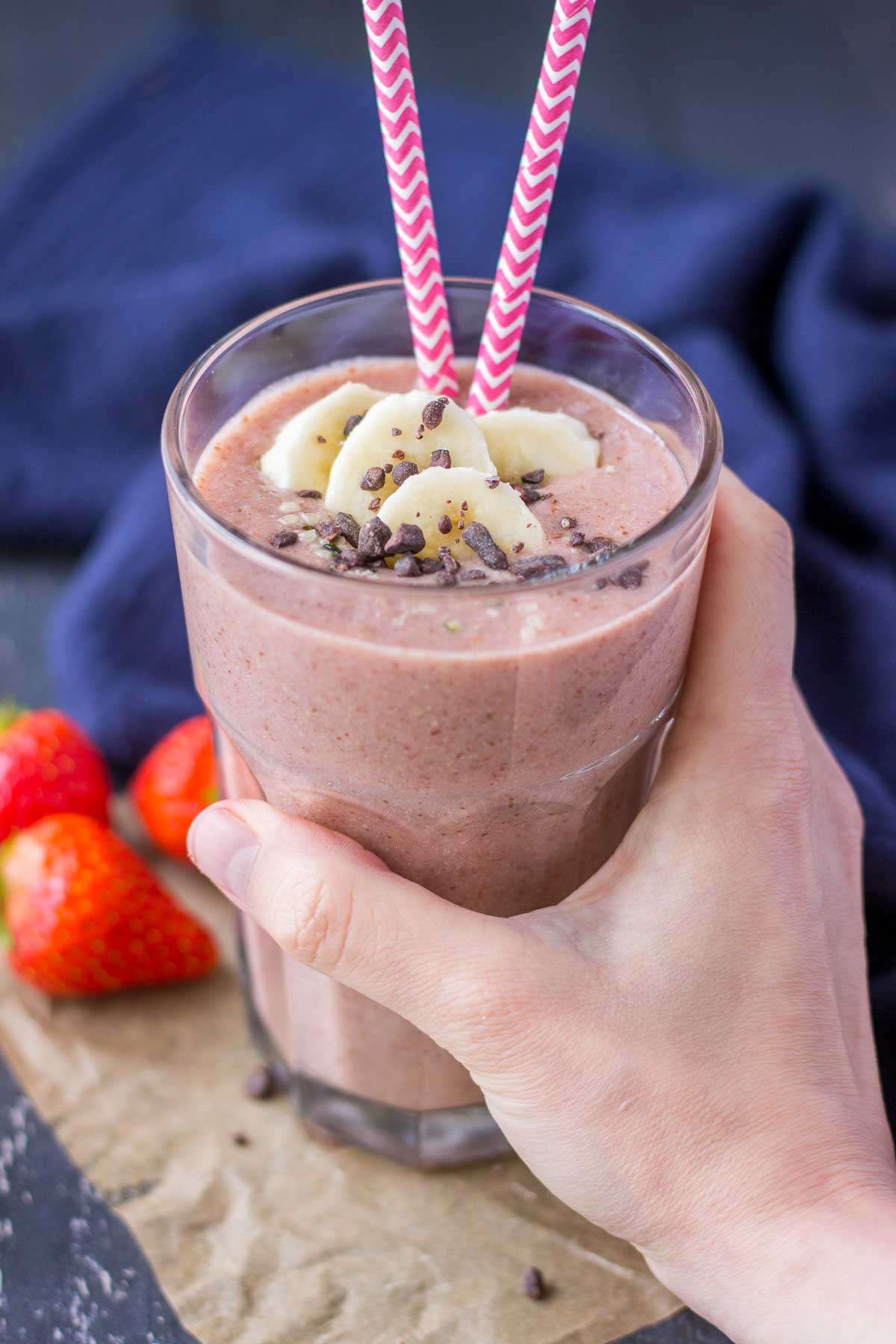 Hand holding Strawberry Banana Smoothie served in a glass
