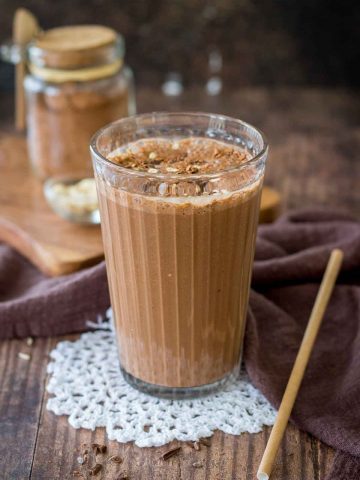 Coffee Smoothie served in a smoothie glass topped with cacao, oats and chocolate
