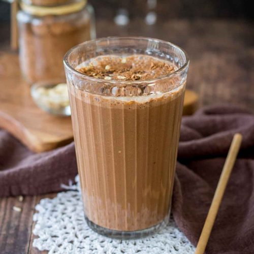 Coffee Smoothie served in a smoothie glass topped with cacao, oats and chocolate