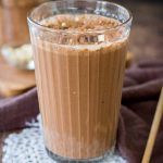 Coffee Smoothie served in a smoothie glass topped with cacao, oats and chocolate