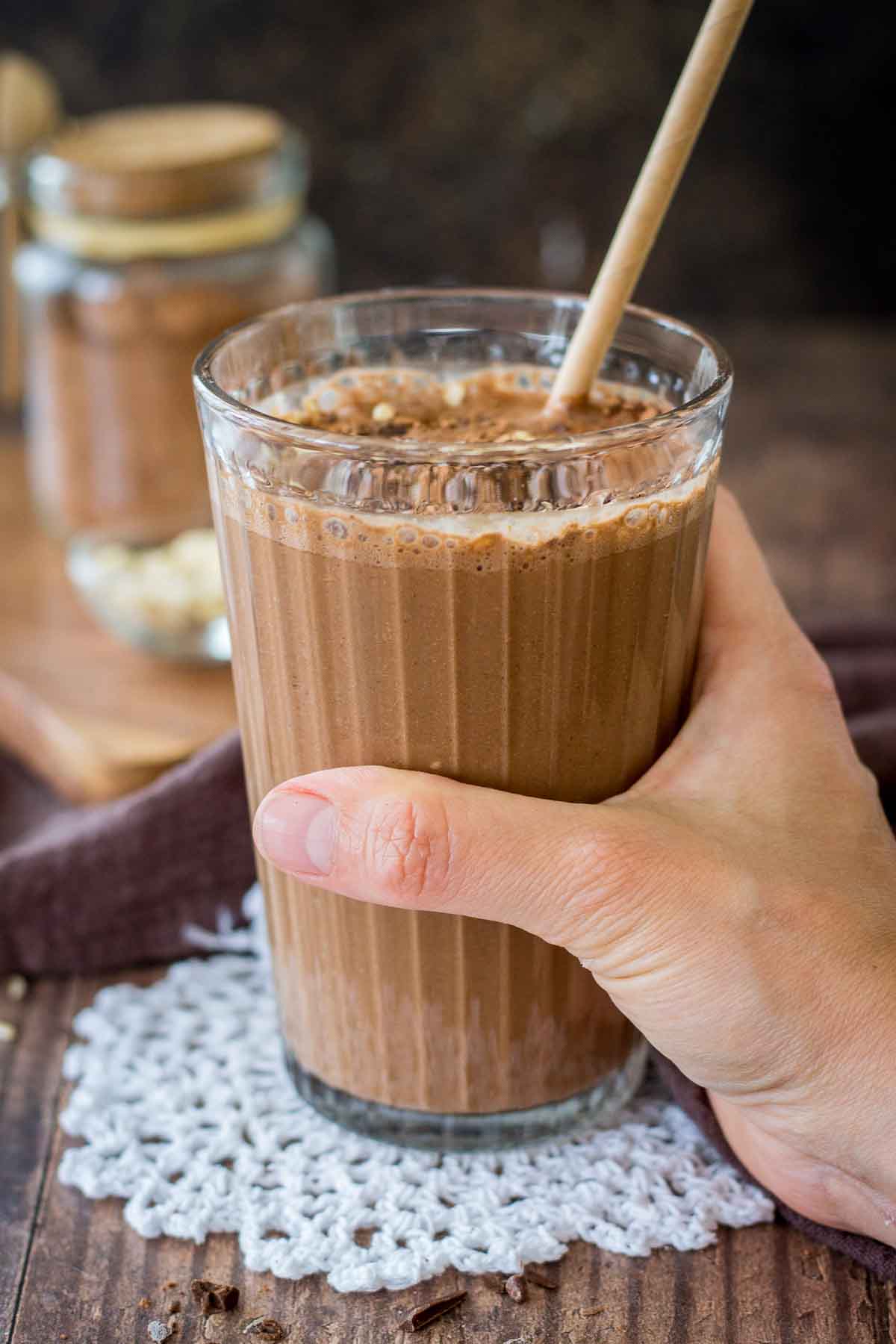 Hand holding Coffee Smoothie served in a smoothie glass with a straw