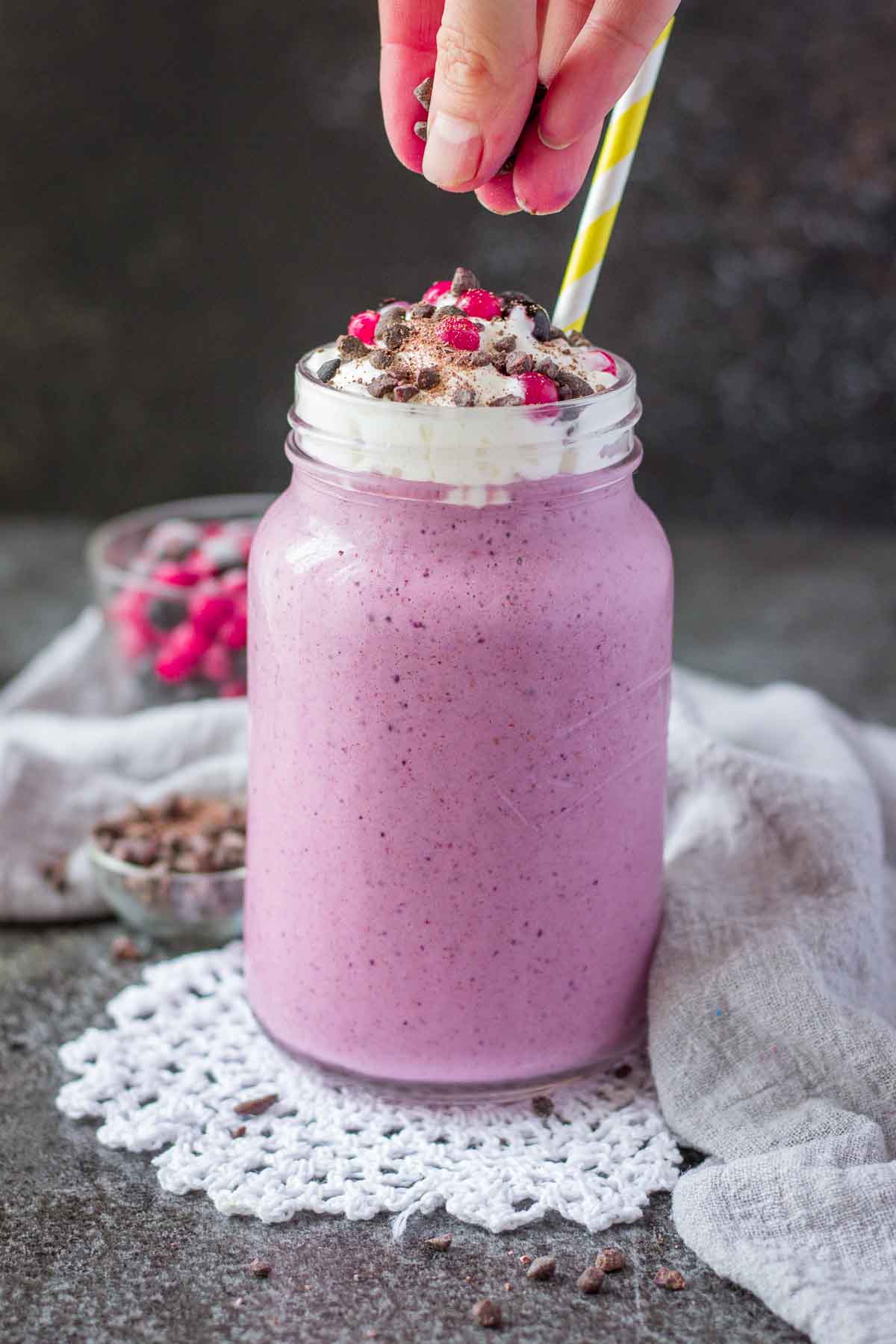 Berry Smoothie topped with cream served in a glass with a straw