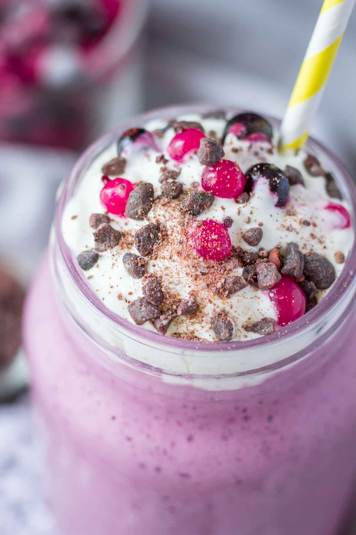 Close view of frozen berry smoothie topped with cream