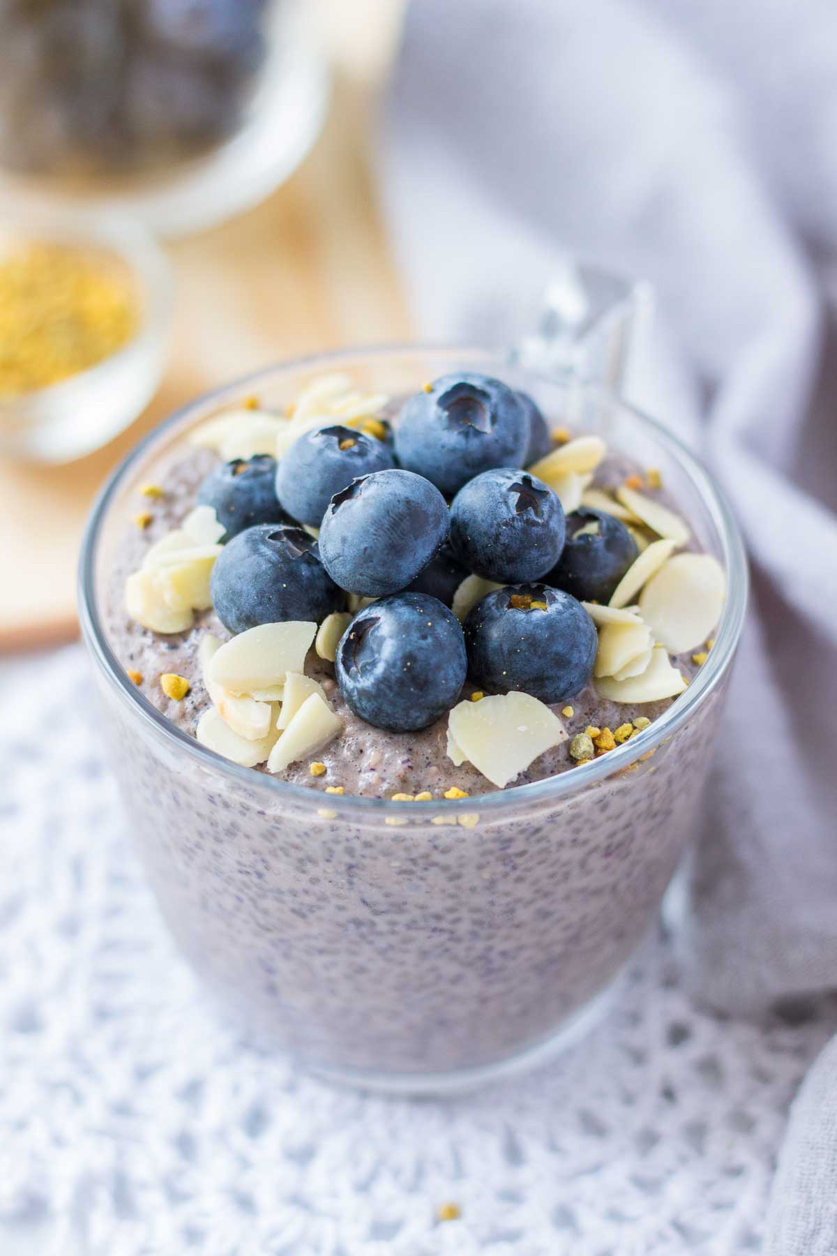 Close up of Blueberry Chia Pudding served in a glass bowl topped with fresh blueberries and almonds