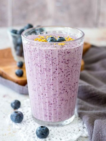 Blueberry Chia Smoothie served in a tall glass topped with fresh blueberries