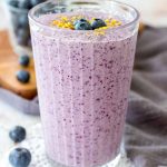 Blueberry Chia Smoothie served in a tall glass topped with fresh blueberries