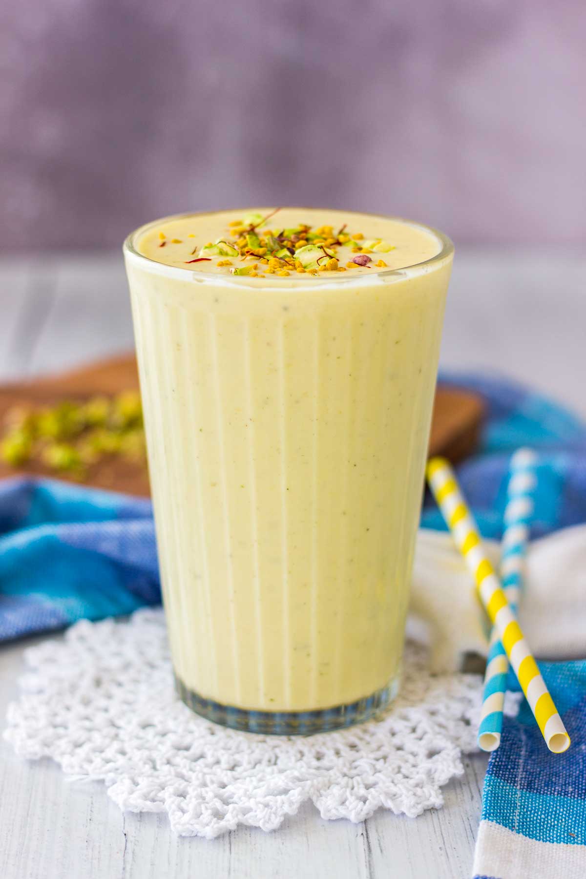 Mango Lassi served in a glass topped with crushed pistachio