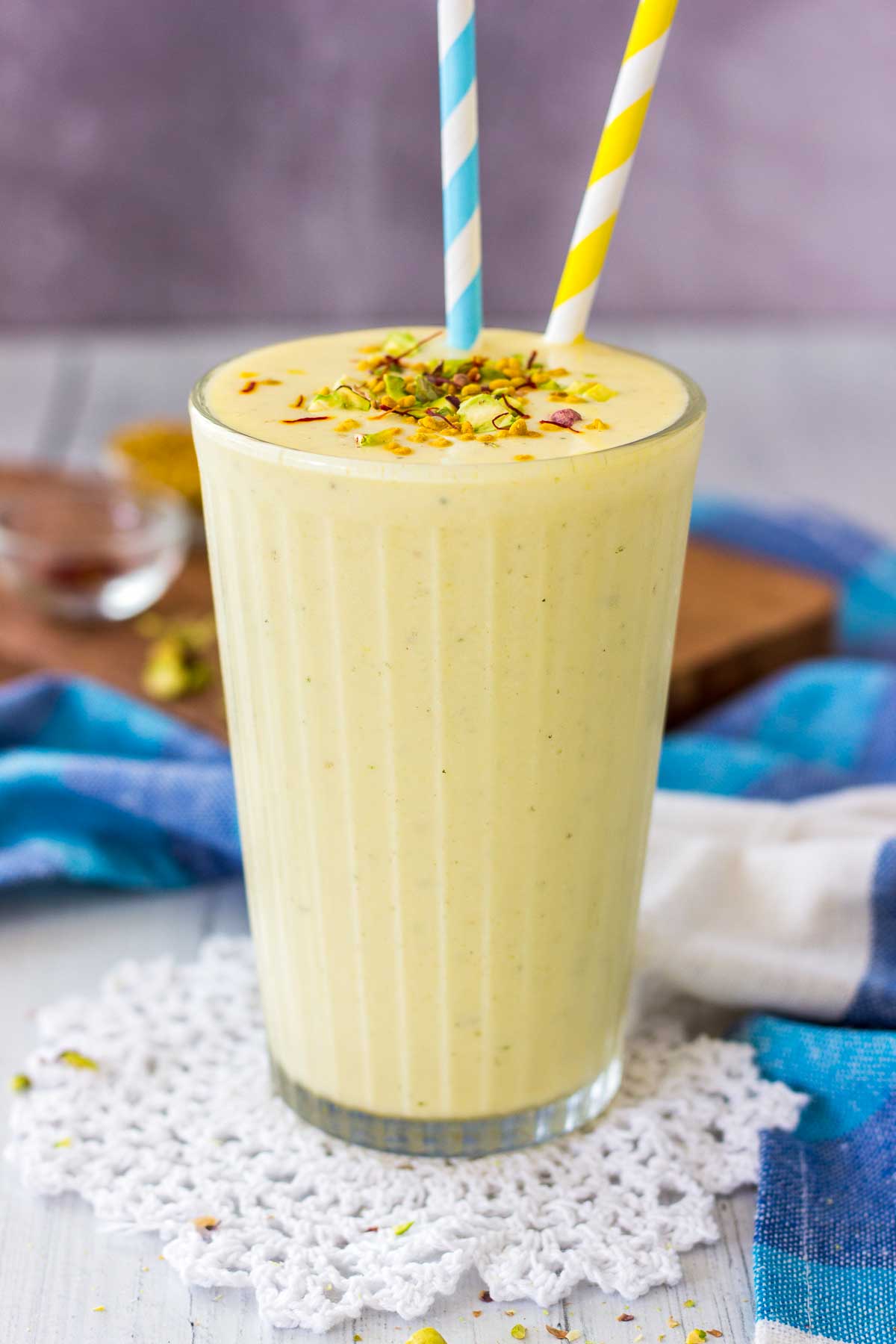 Mango Lassi served in a glass with two straws