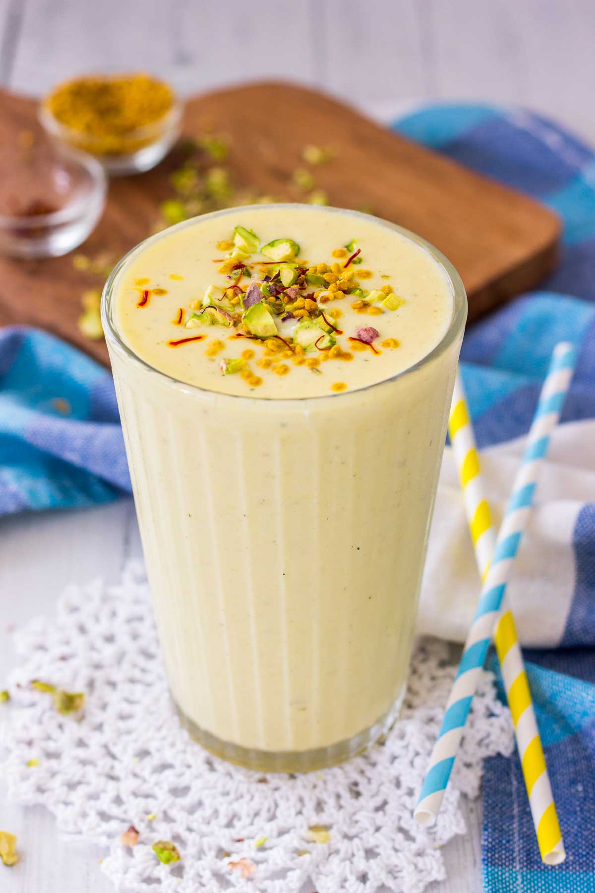 Mango Lassi served in a glass topped with crushed pistachio