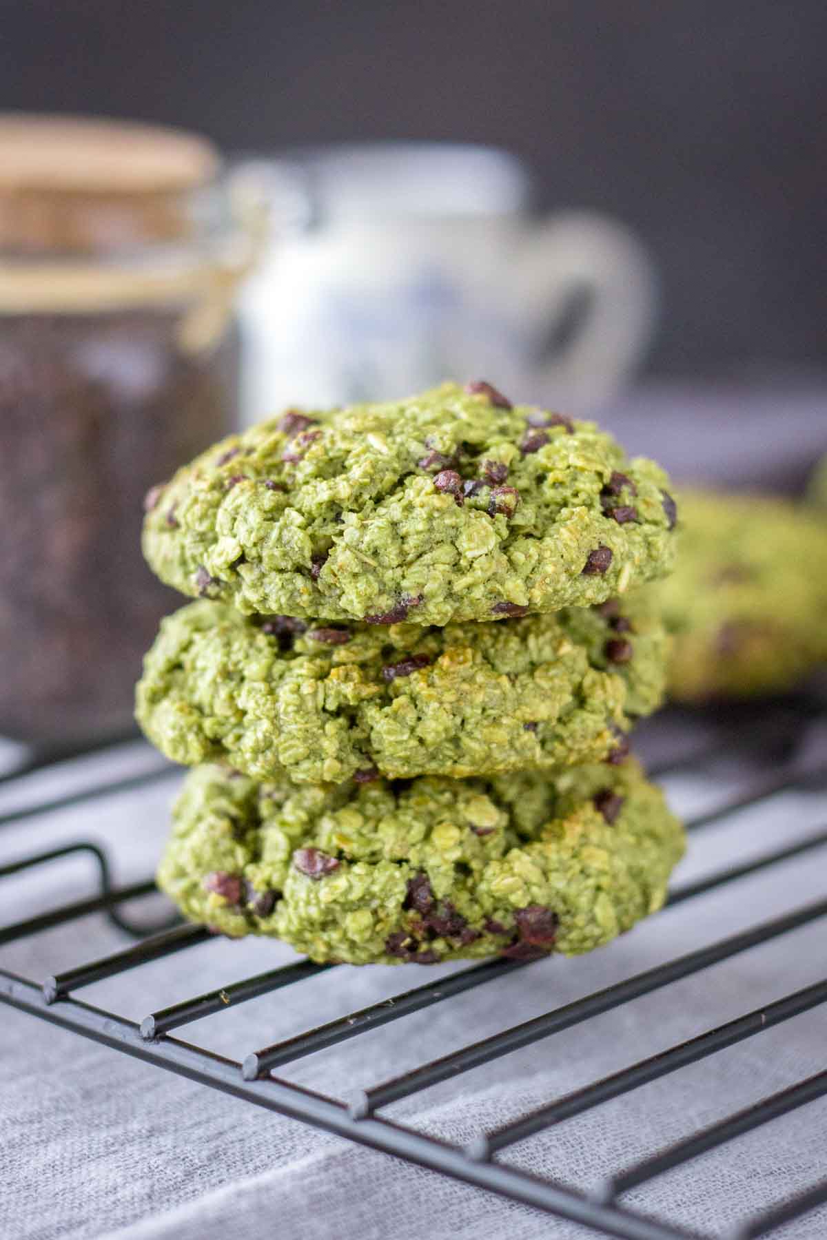 Matcha Chocolate Chip Cookies stacked on a cooling rack