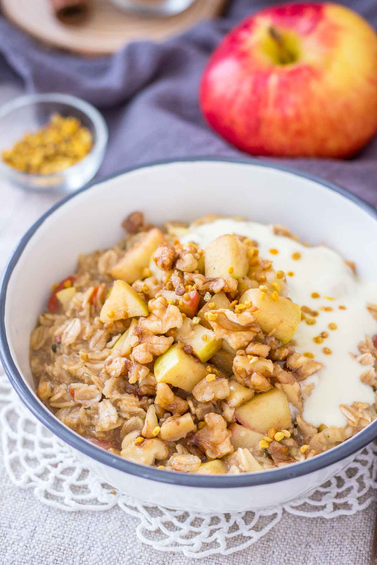 Apple Cinnamon Oatmeal served in a bowl topped with diced apples, walnuts and yogurt