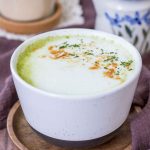 Matcha Maca Latte served in a mug topped with matcha green tea powder and maca powder