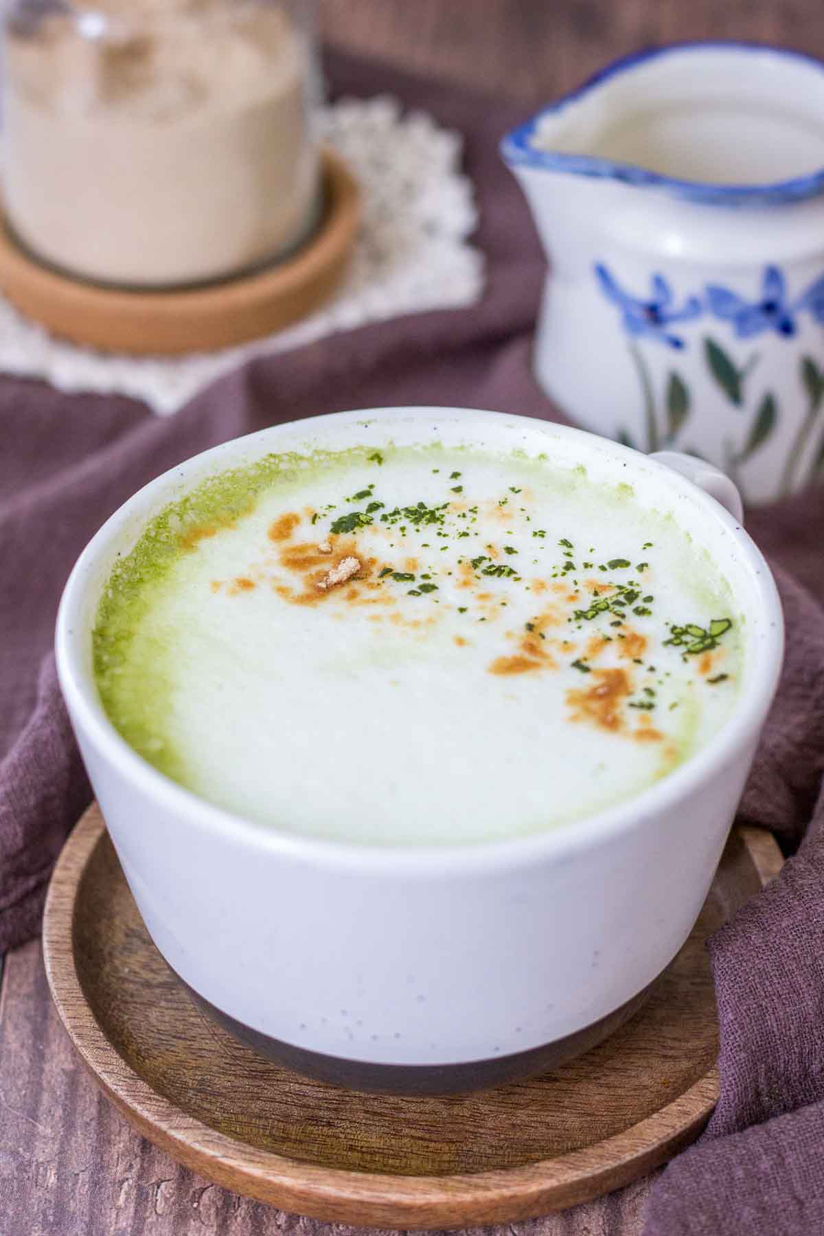 Matcha Maca Latte served in a mug topped with matcha green tea powder and maca powder