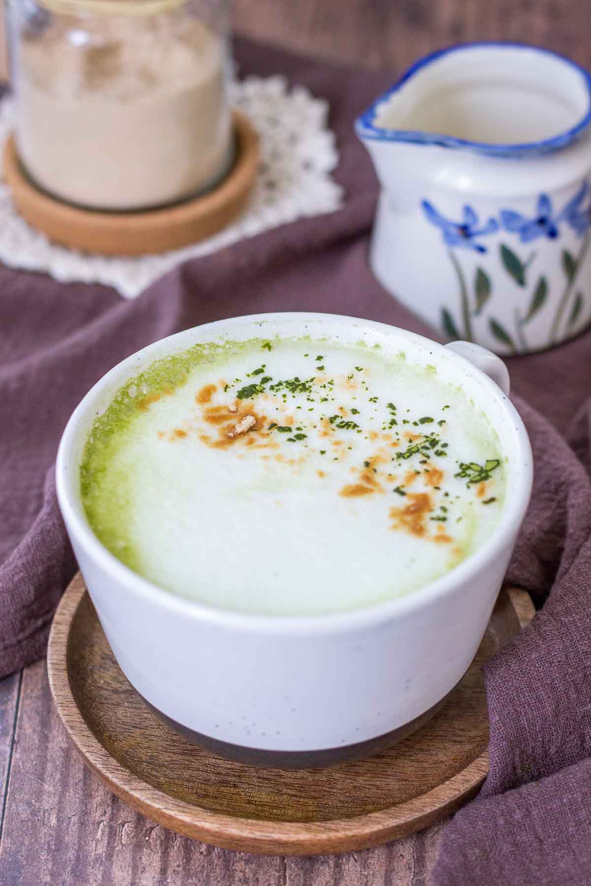 Matcha Maca Latte served in a mug topped with matcha green tea powder and maca powder