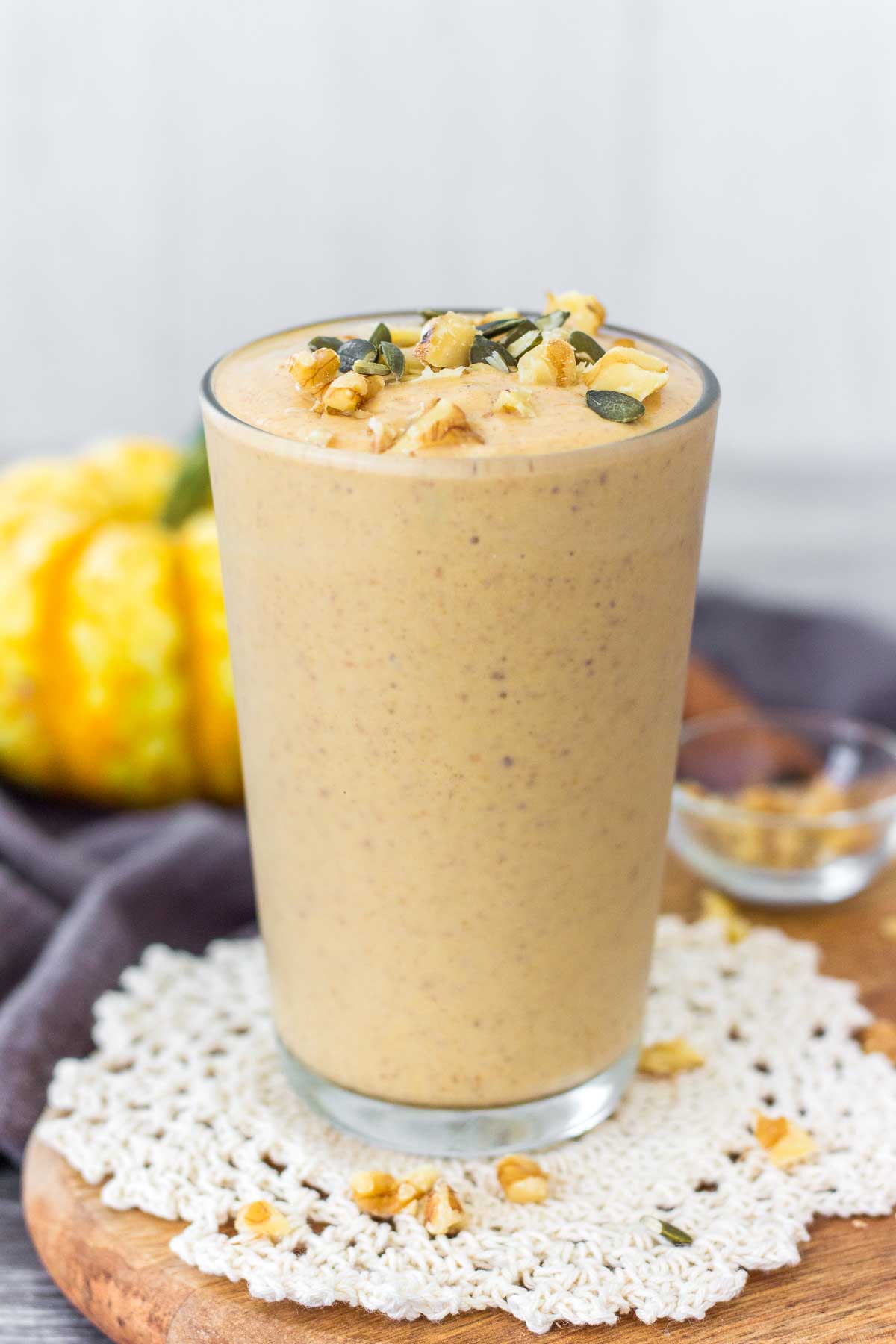 Pumpkin Smoothie served in a glass topped with walnuts and pepitas