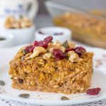 Pumpkin Baked Oatmeal served on a plate topped with walnuts and cranberries
