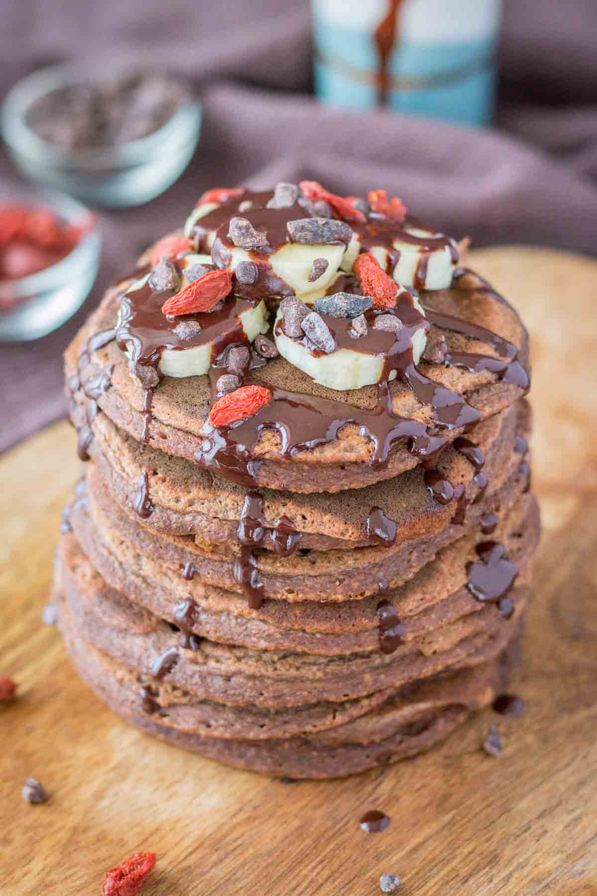 chocolate and banana pancakes topped with banana slices and chocolate syrup