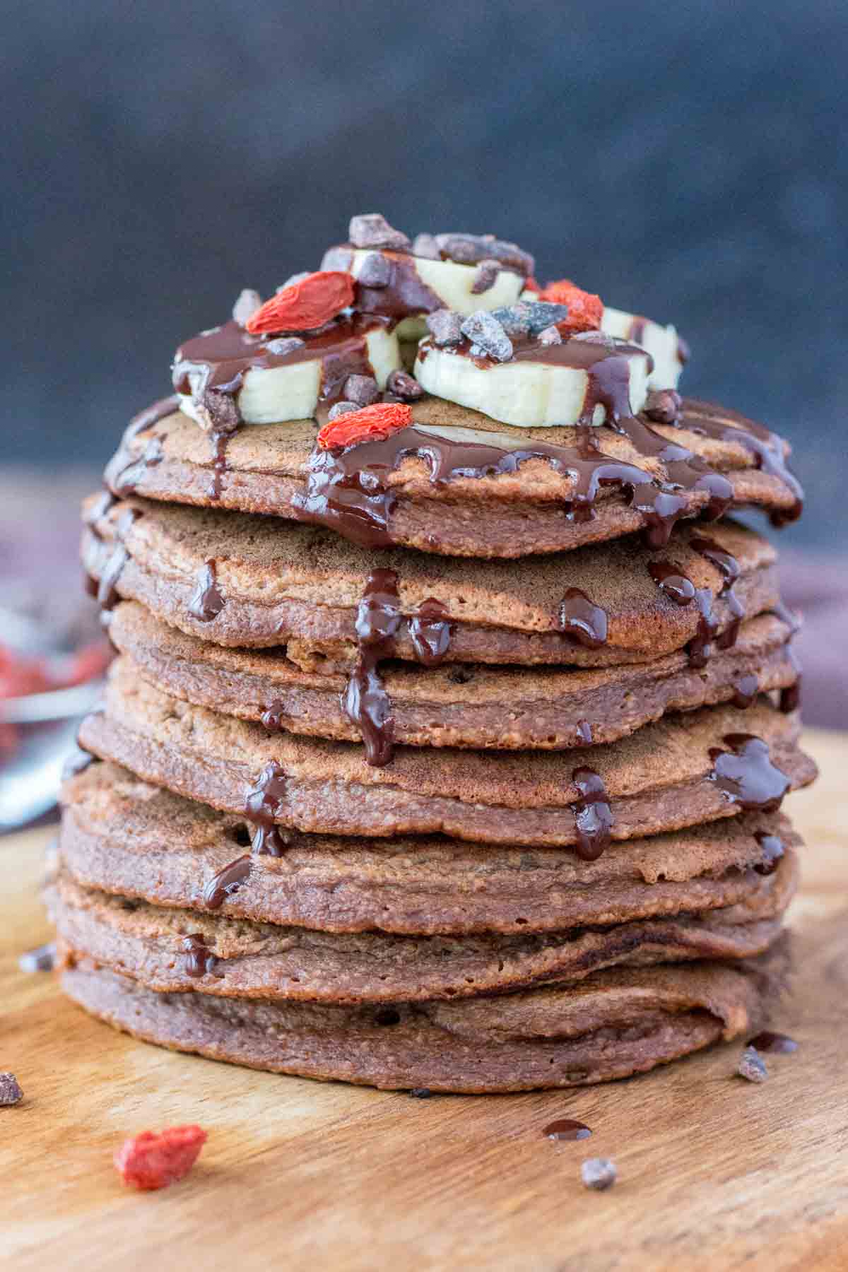 oatmeal chocolate pancakes topped with banana slices and chocolate syrup